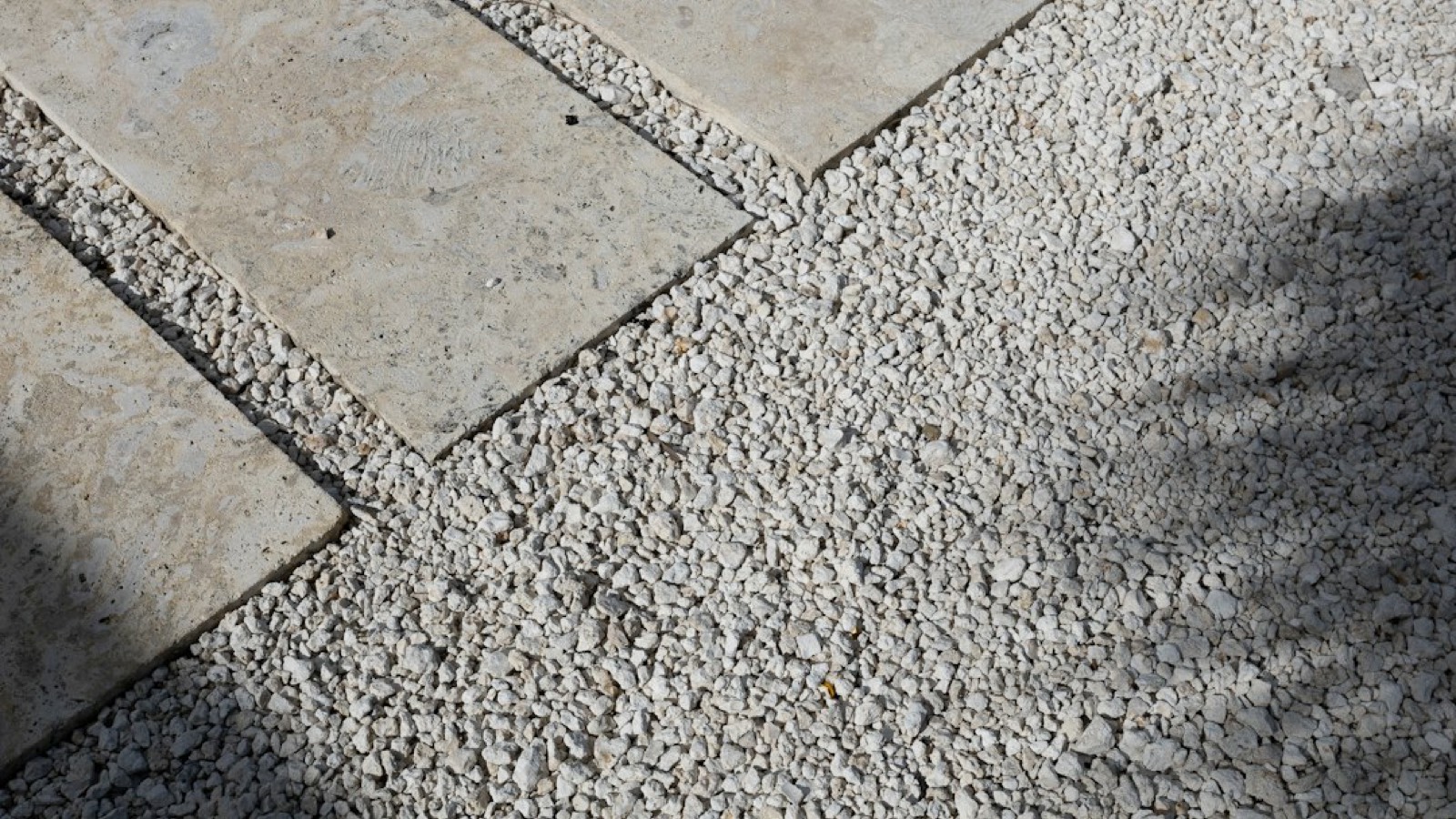 outil de nivelage posé sur un lit de gravier pour la pose d'une plaque de jardin